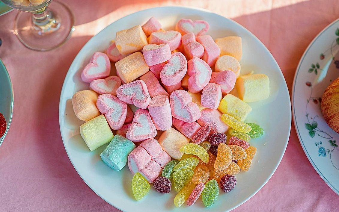 A curated gift hamper of chocolates, sweets and lollipops tied with ribbon